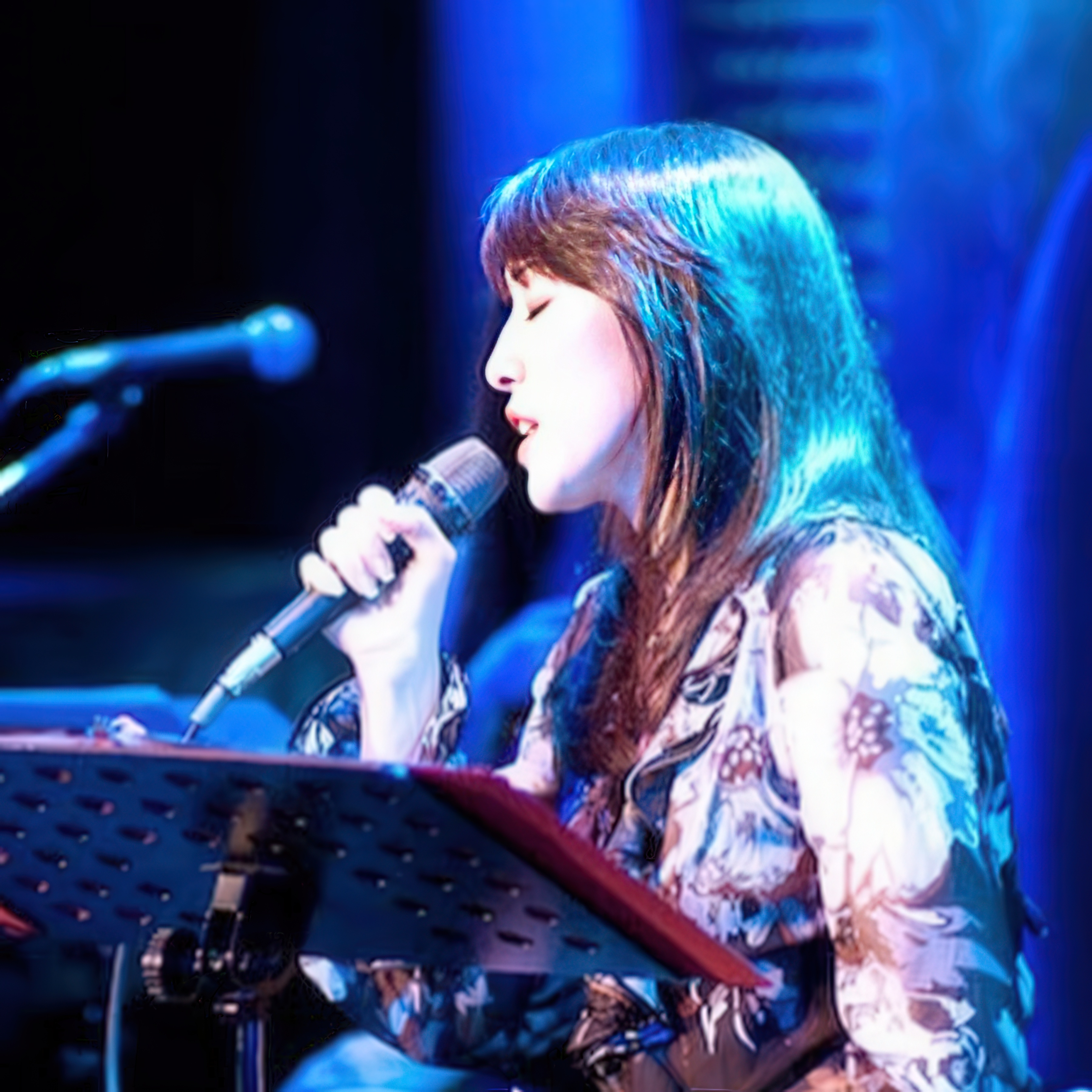 Cindy Asada singing into a microphone on stage